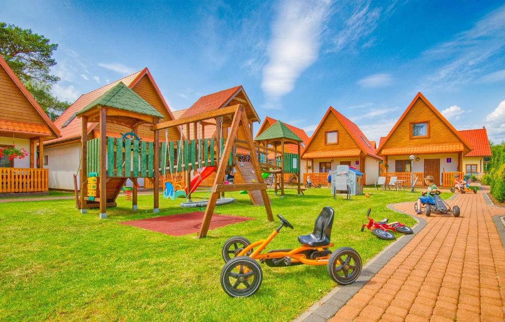a playground with play equipment in a group of houses at Domki SUNSET Bałtycka in Dąbki