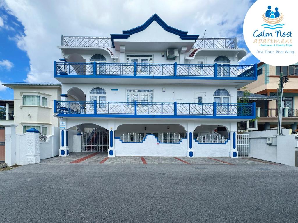 a white building with blue balconies on it at Calm Nest Apartment in Flic-en-Flac