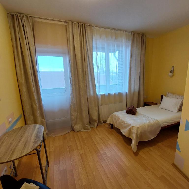 a bedroom with a bed and a large window at Arsenal in Daugavpils