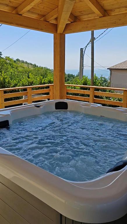 a hot tub on a deck with a wooden fence at La Locanda del Voltigno in Villa Celiera