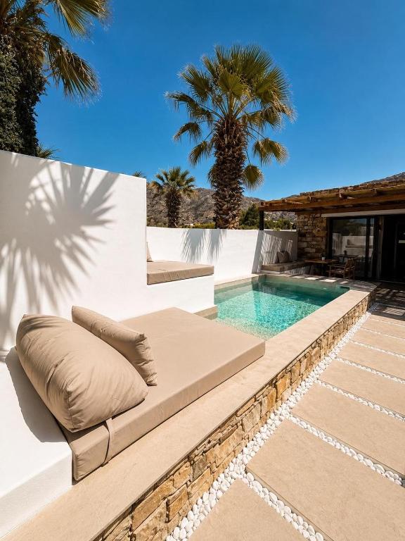 a swimming pool with a chaise lounge next to a swimming pool at ARC suites in Mylopotas