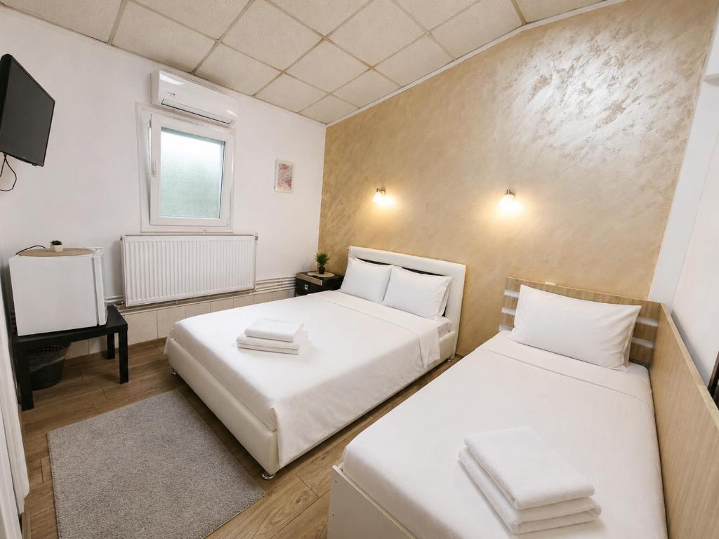 two beds in a small room with a television at Agape Speranta 96 in Piteşti