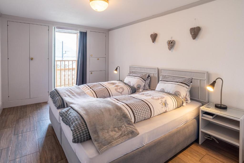 a bedroom with a large bed with two pillows at Double Room by Interlaken. Parking in Därligen
