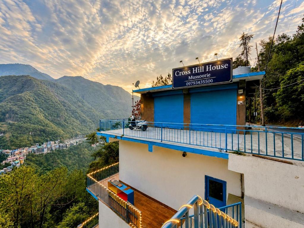 a building with a sign on top of it at Cross Hill House Mussoorie in Mussoorie