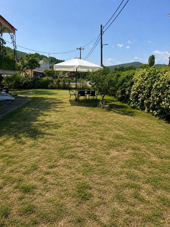 a picnic table with an umbrella in a yard at Stavros Green & Sea Holiday Home in Stavros