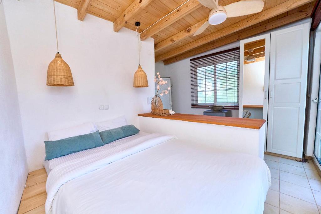 a bedroom with a white bed and a window at Billion Stars Studio in Thymonia Beach
