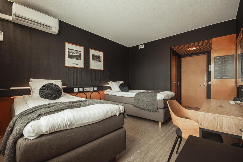 a hotel room with two beds and a table at Hotelli Jämsä in Jämsä