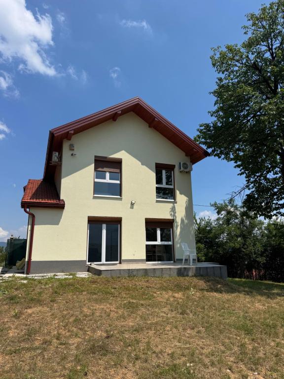 a yellow house on top of a grass field at Sky view villa in Obrovac