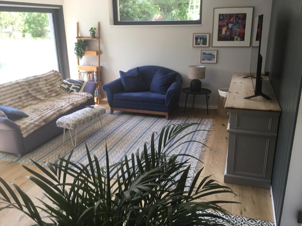 a living room with a blue chair and a couch at Stunning New Apartment Senningerberg in Niederanven