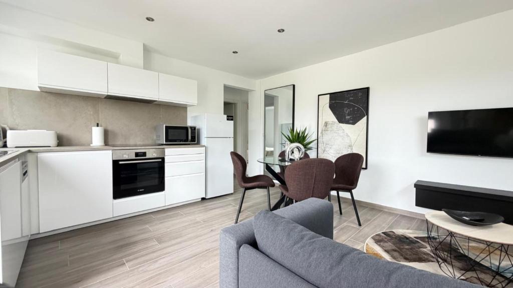 a kitchen and living room with a couch and a table at L'Annexe in Arlon