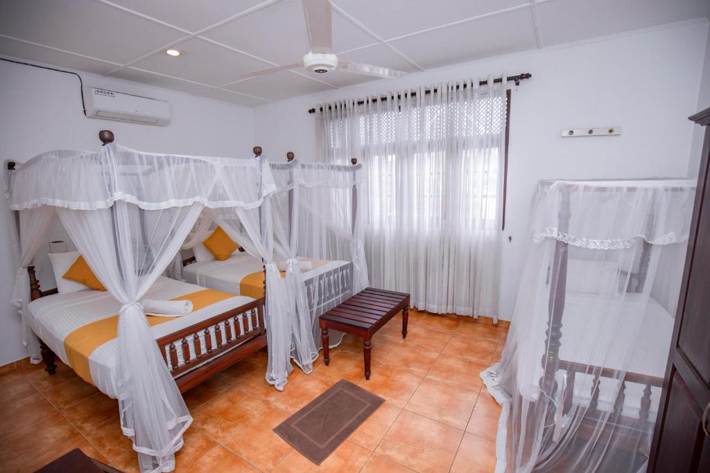 a bedroom with a canopy bed and a chair at KapuGedara297 in Galle