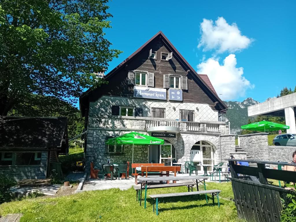 a building with a picnic table in front of it at Planinski dom Hermanov Hram in Log pod Mangartom