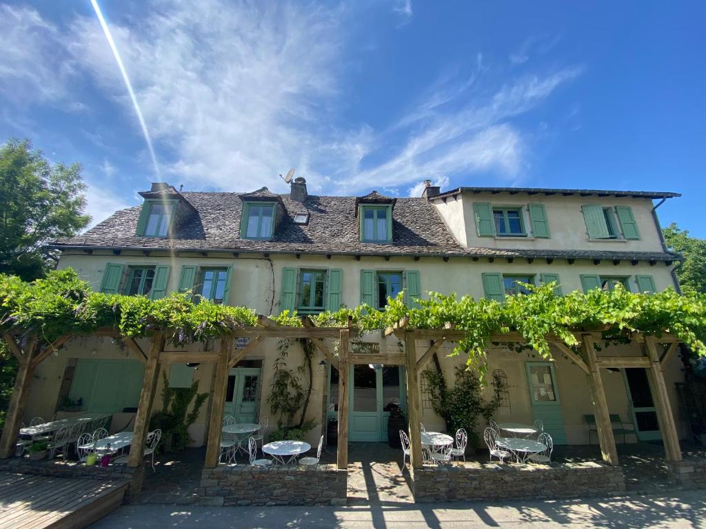 a large house with a covered porch with vines at Auberge du Fel in Le Fel