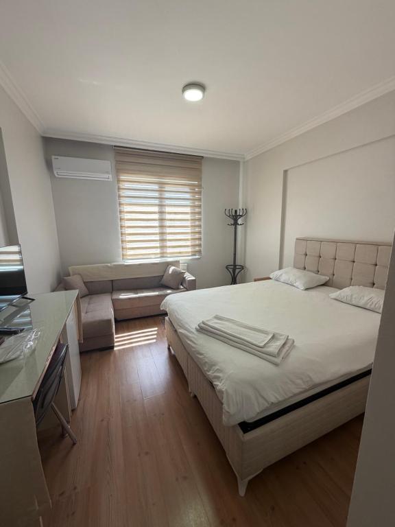 a bedroom with a large bed and a couch at Korkmaz Rezidans in Kayseri