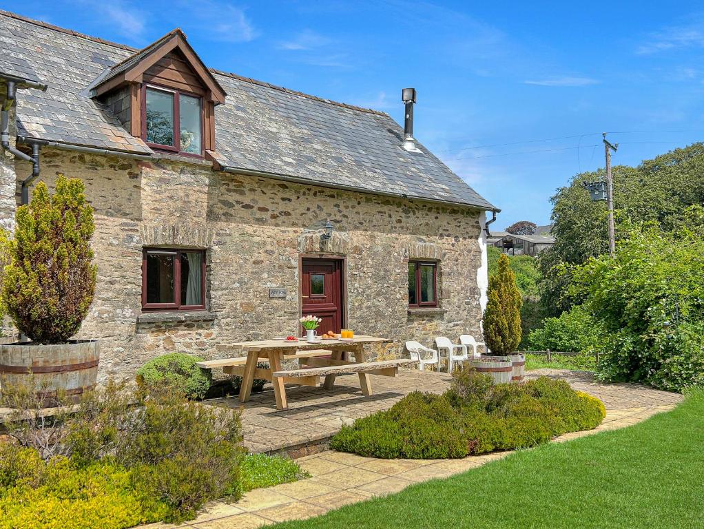 a stone house with a picnic table in front of it at Norton Cottage Hawkridge in Dulverton