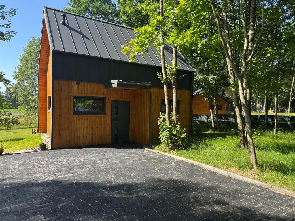 a barn with a black roof and a garage at Stodoła in Kamień