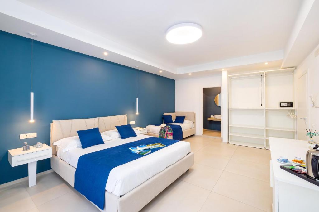 a bedroom with a large bed and a blue wall at Le Stagioni Rooms in Vieste
