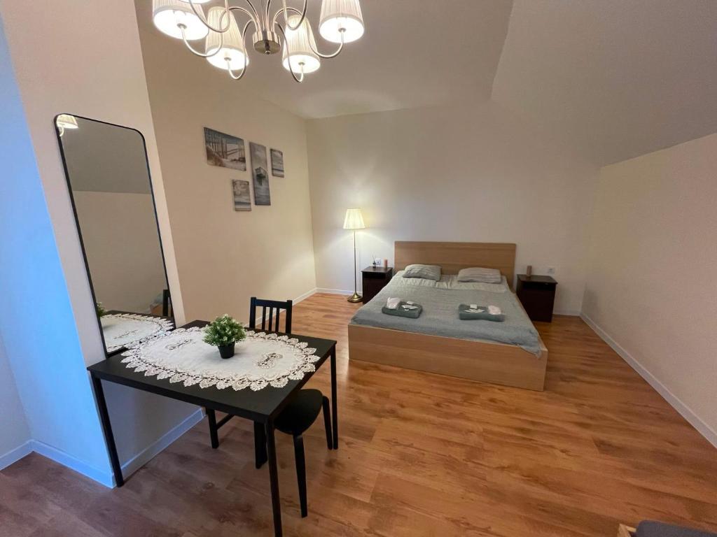 a bedroom with a bed and a table and a mirror at K14 Stay 3 in Riga