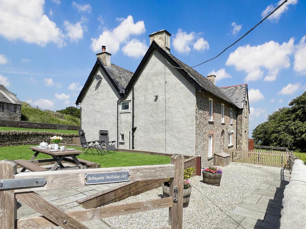 a white house with a picnic table in front of it at Wingate Farm Countisbury in Countisbury