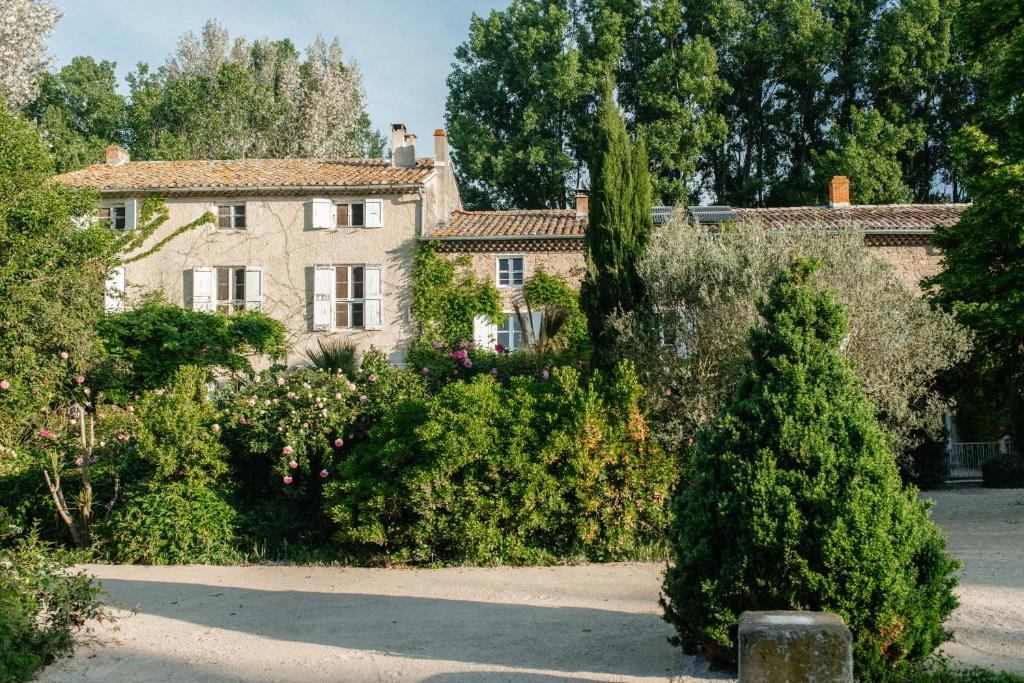 a large stone house with a bunch of bushes at Casa tudo bem in Pernes-les-Fontaines