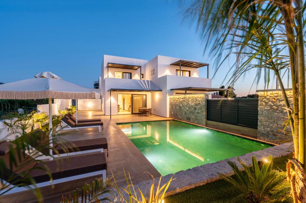 a villa with a swimming pool in front of a house at SoleLuna - The Villas Project in Marmaroto