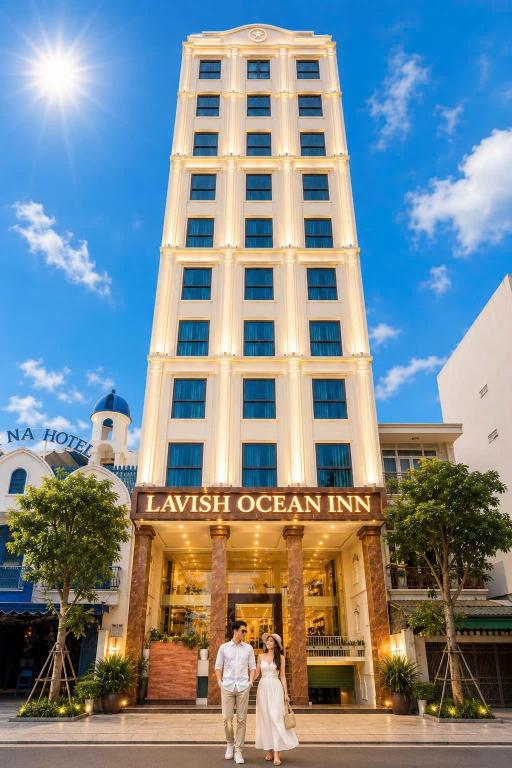 a couple walking in front of a tall building at LAVISH OCEAN INN Đà Nẵng in Danang