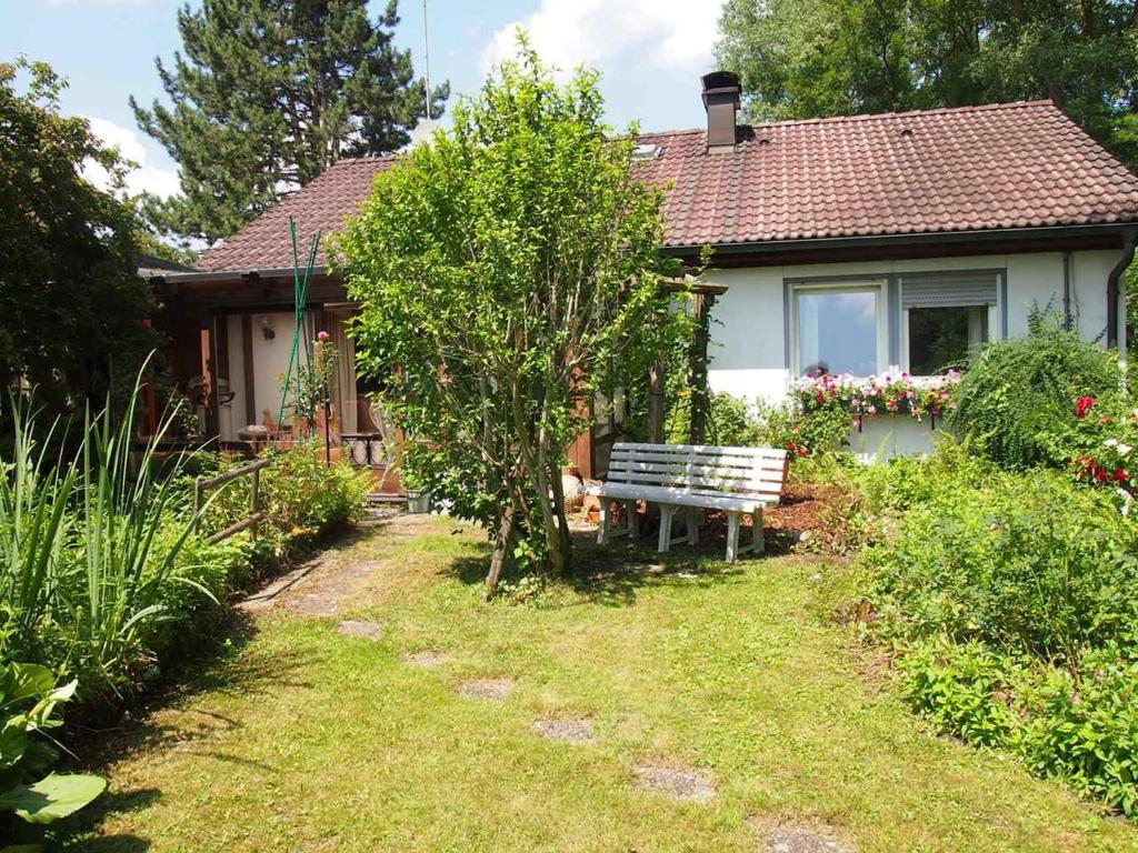 a small house with a bench in the yard at Ferienhaus-in-idyllischer-Lage in Inning am Ammersee