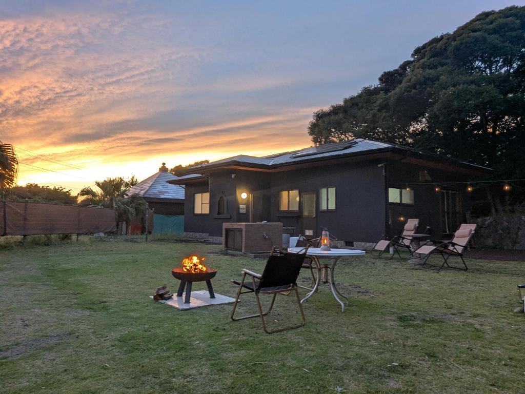 a house with a table and chairs in the yard at Big Island Base 一組限定の庭付き一棟貸し BBQ 焚き火 テントサウナ 最大6名 in Oshima