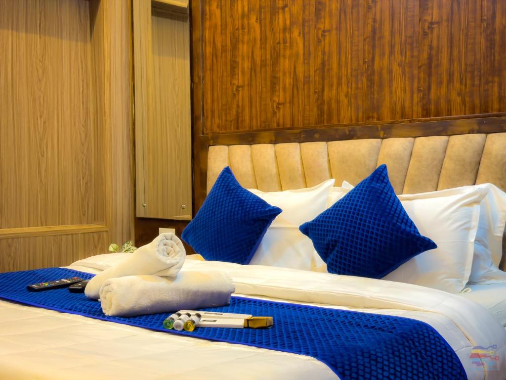 a bed with blue and white pillows and blue pillows at Guruvayur Dham 200 mtr from Mathura Railway Station in Mathura