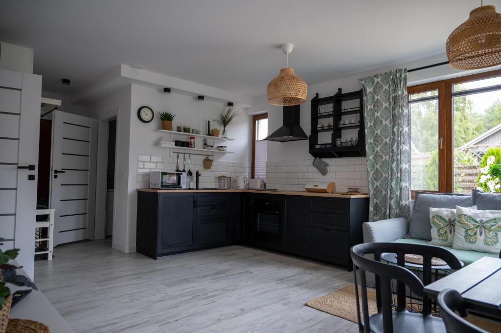 a kitchen with black cabinets and a table and chairs at Apartament Roberto in Żarnowska