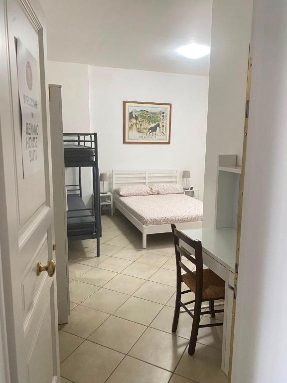 a bedroom with a bed and a desk with a chair at Renaio House Buti in Bientina
