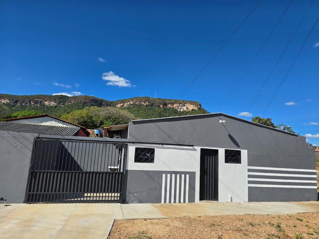 a gray and white building with a mountain in the background at Microcasa 6 in Lajeado