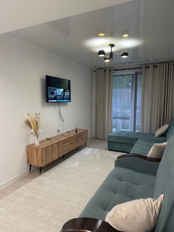 a living room with a couch and a tv at Атлантис in Chon-Sary-Oy