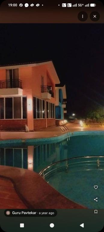 a picture of a house and a swimming pool at night at Casa asud Dapoli in Dapoli