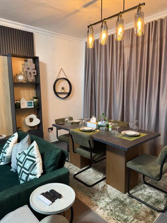 a living room with a table and a green couch at F&F Villa in Tema