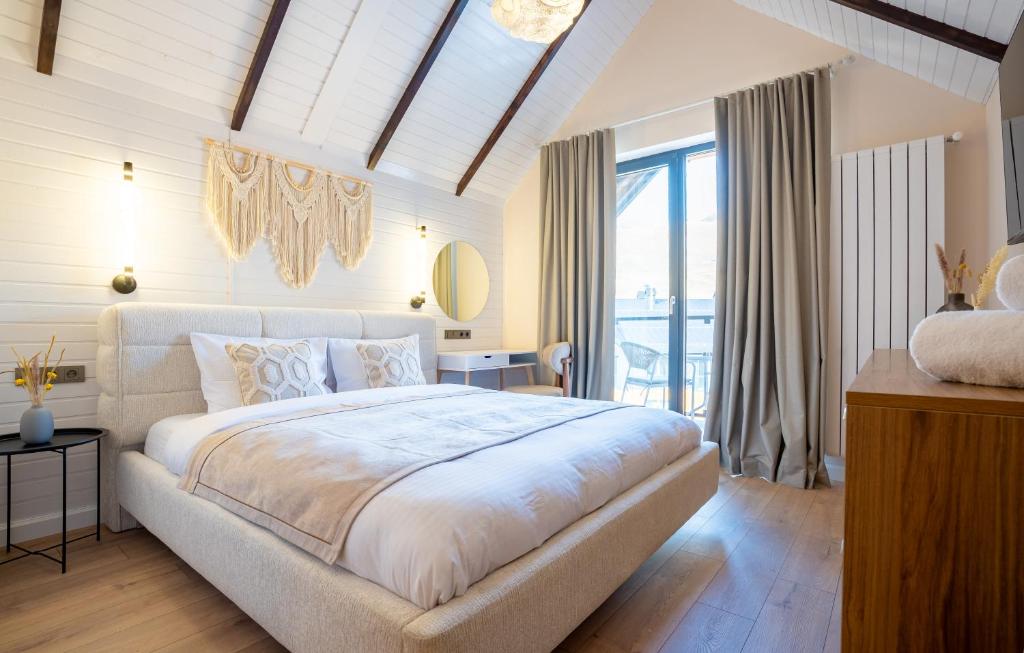 a bedroom with a large bed and a large window at New Gudauri Viva Seasons in Gudauri