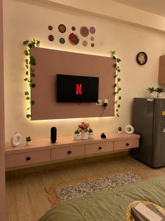 a living room with a television on a wall at The cozy cave in Jaipur