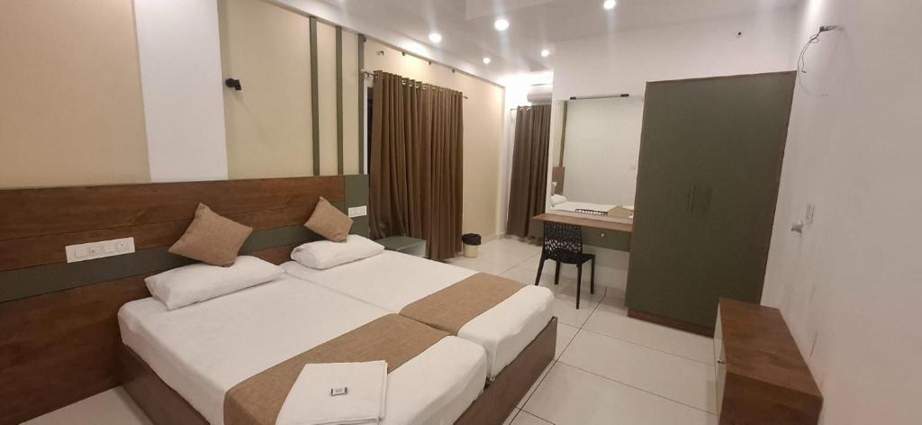 a bedroom with a bed and a desk and a mirror at Aashi's Inn in Alleppey