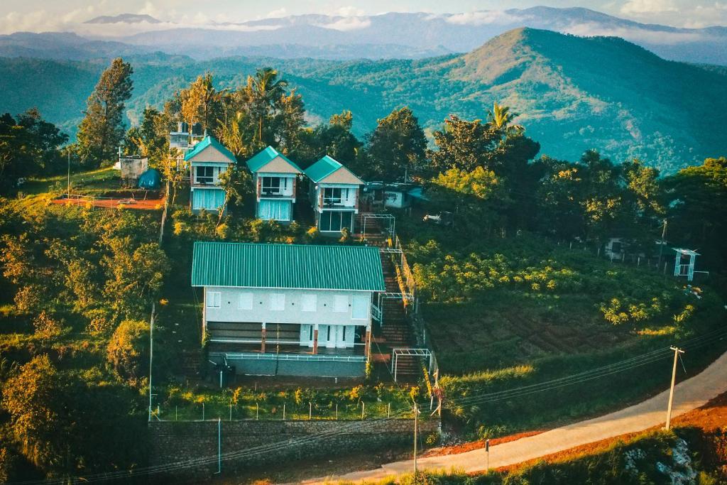 a house on a hill with mountains in the background at Floresta Resort in Kūmudi