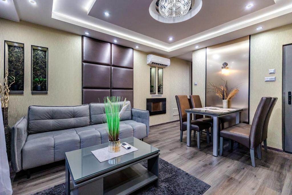 a living room with a couch and a table at Royal Apartments Hotel Kecskemét in Kecskemét