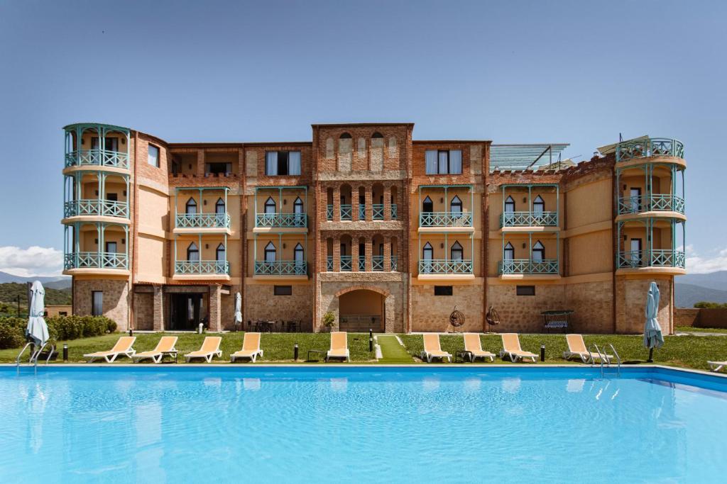 a large building with a large swimming pool in front of it at Burki Castle & Cellar in Kvareli