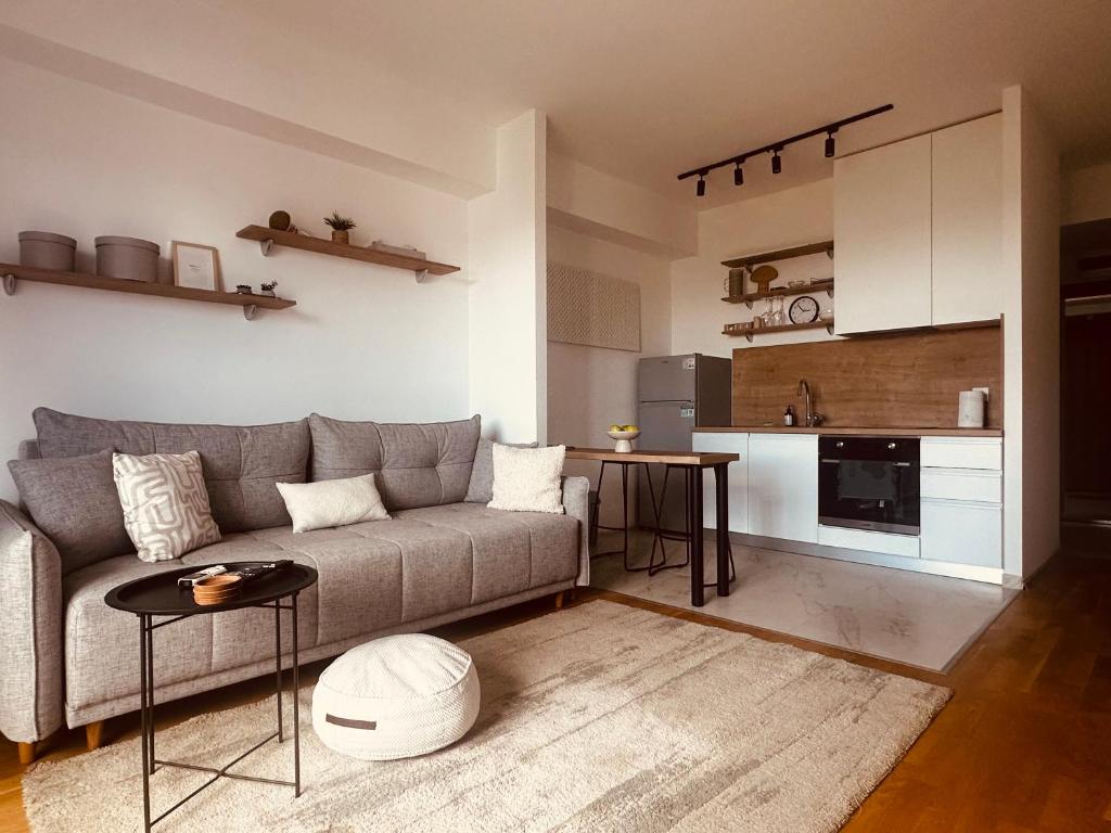 a living room with a couch and a kitchen at City nest Skopje in Skopje