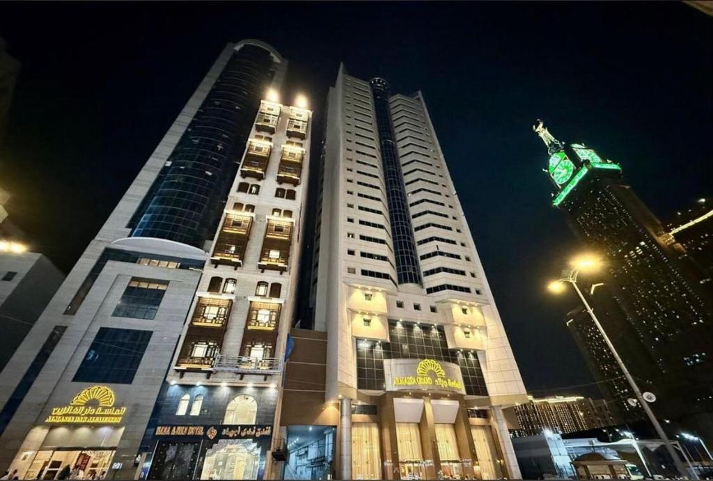 a tall building at night with its lights on at فندق ندى أجياد in Ajyad