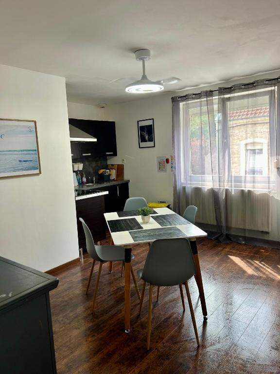 a kitchen and dining room with a table and chairs at Not far from Wissant in Marquise