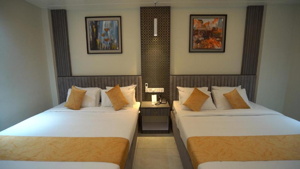 two beds in a hotel room with two at The Swiss Hotel & Resort in Cox's Bazar