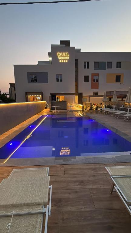 a large blue swimming pool in front of a building at Hotel Venere in Ascea