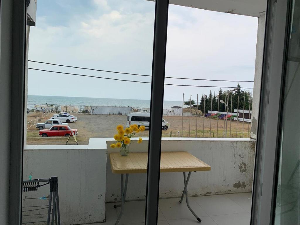 ein Fenster mit einem Tisch und Blick auf den Strand in der Unterkunft Террас 5 in Astara