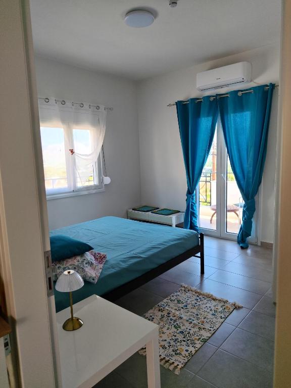 a bedroom with a blue bed and a window at NMD house in Ermioni