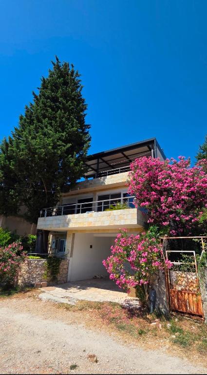 a building with pink flowers in front of it at Villa Tesoro in Kruče