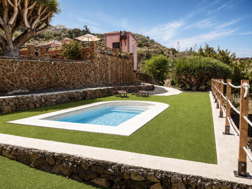 a swimming pool in a yard with a stone wall at Celeste in Mazo